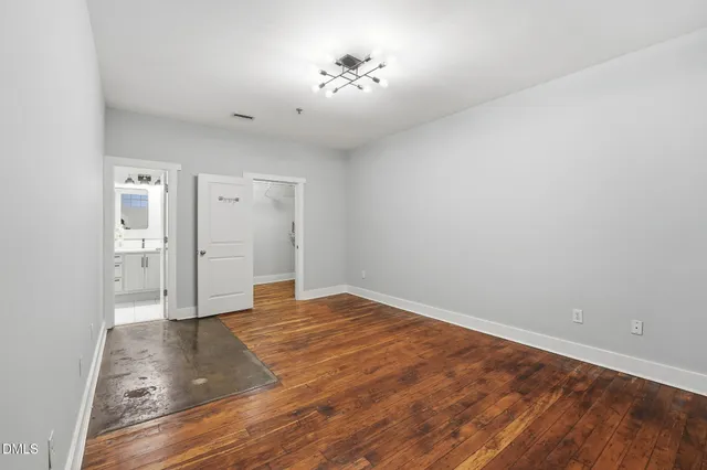 a view of empty room with wooden floor