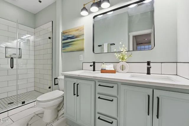 a bathroom with a sink a toilet and shower