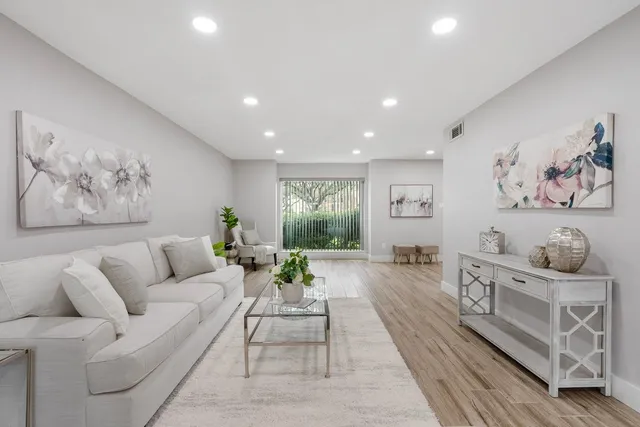 a living room with furniture and wooden floor