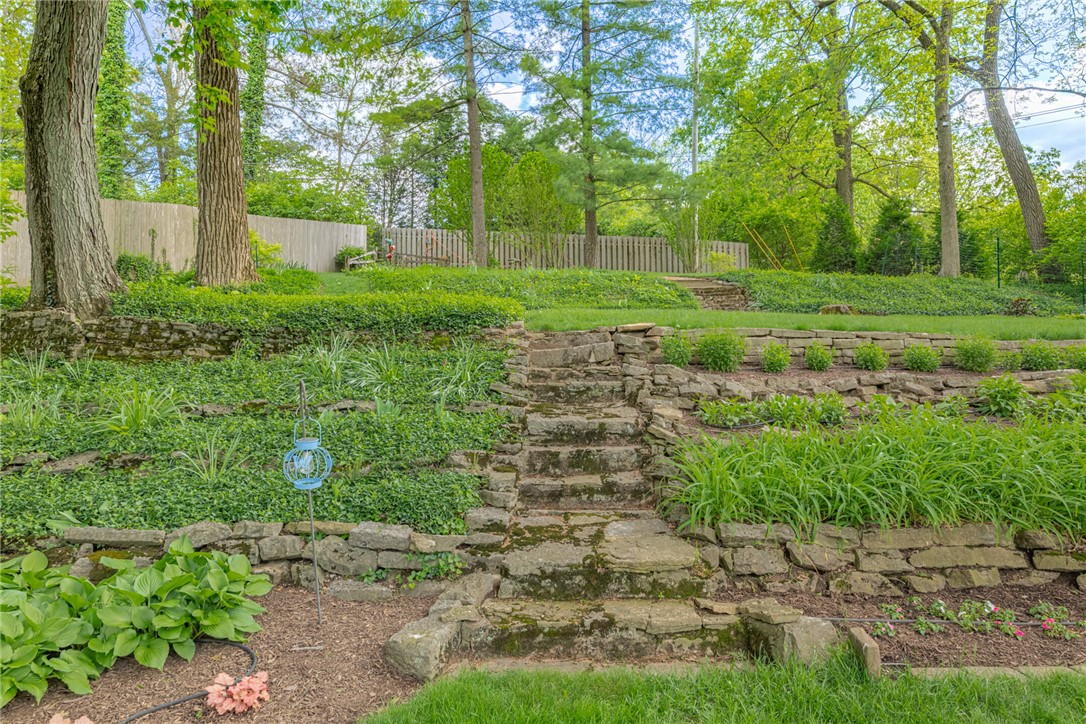 156 West Hadley Road Dayton, OH 45419 - Photo 52 of 71 This tranquil yard features lush landscaping and natural stone steps, creating a picturesque outdoor retreat.