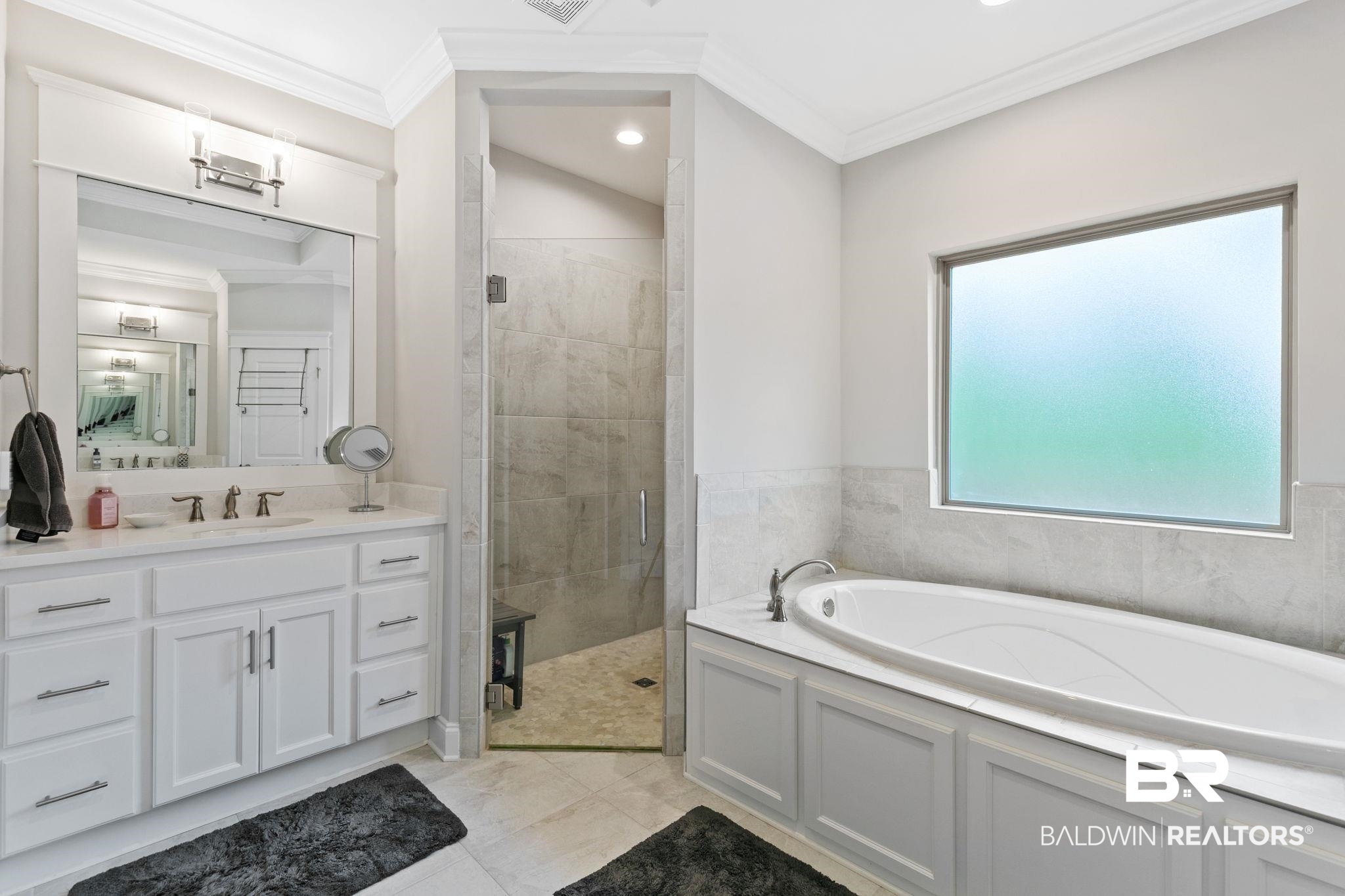 13233 Ibis Boulevard Daphne, AL 36527 - Photo 32 of 100 Spacious bathroom featuring a built-in soaking tub, an expansive vanity with dual sinks, a large walk-in shower with glass enclosure, and a frosted privacy window