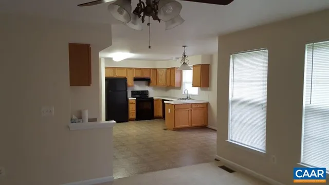 a kitchen with stainless steel appliances kitchen island a refrigerator sink and cabinets