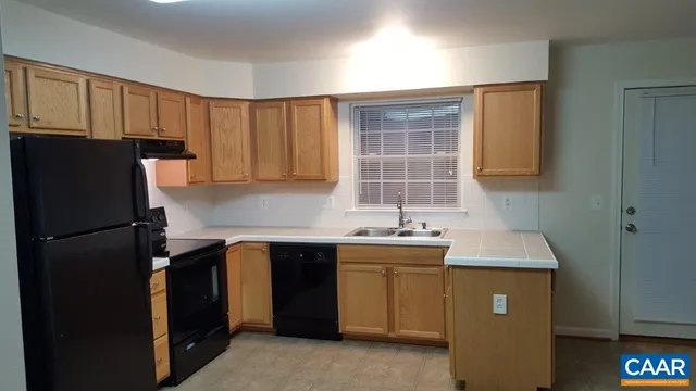 a kitchen with a sink a refrigerator and cabinets