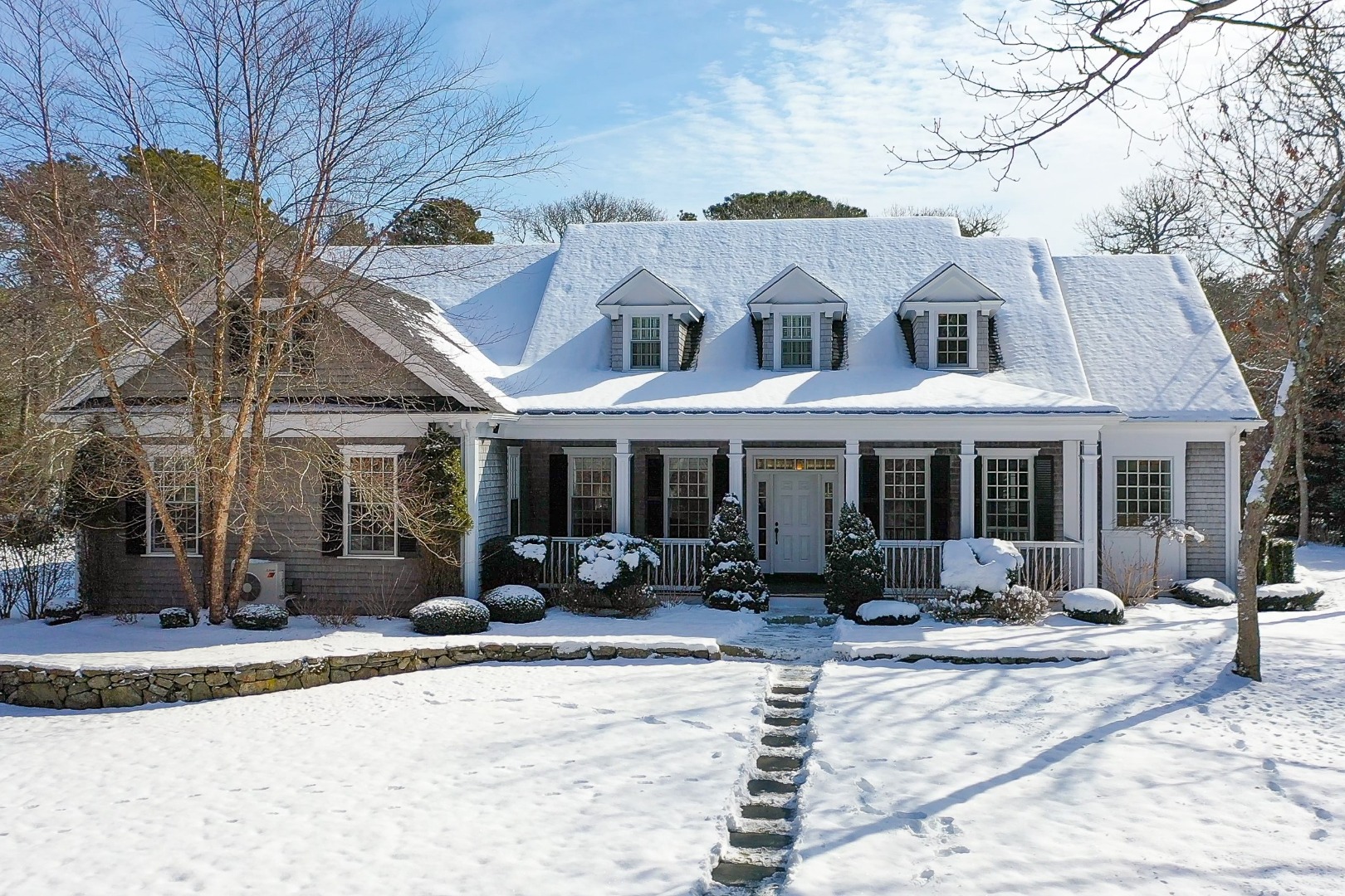 243 Katama Road Edgartown, MA 02539 - Photo 2 of 42 a view of a white house with table and chairs under an umbrella