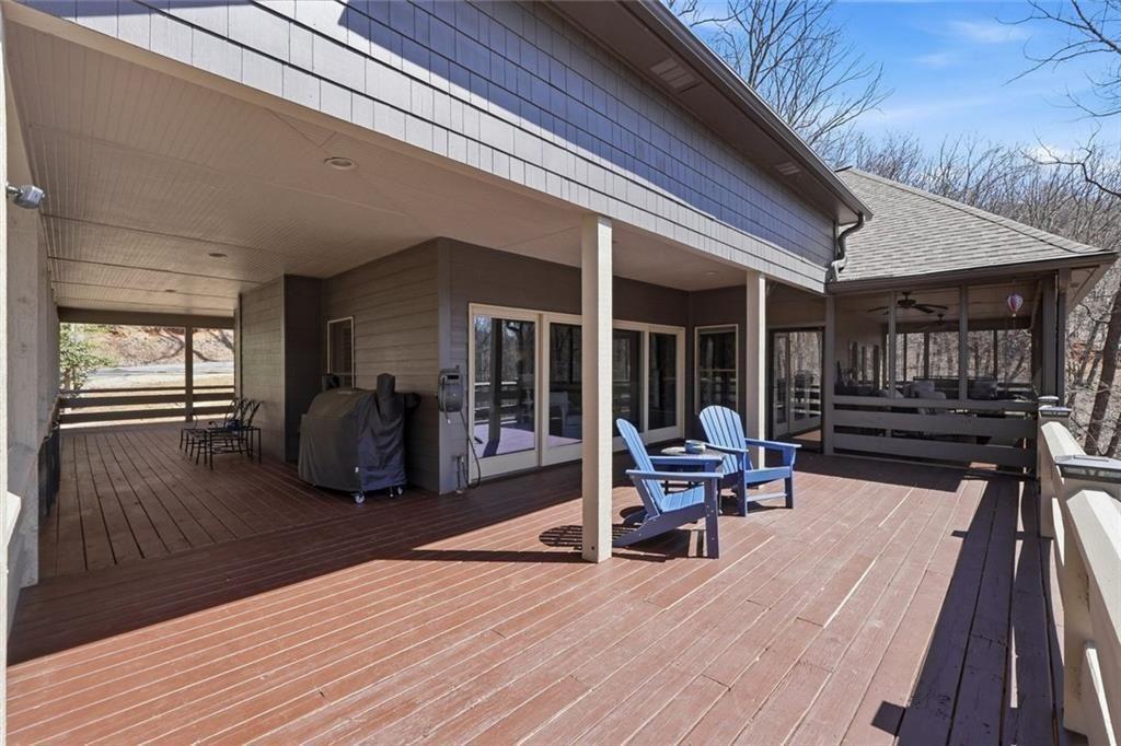 2162 Valley View Drive Jasper, GA 30143 - Photo 23 of 52 a view of a deck with table and chairs with wooden floor and floor to ceiling window