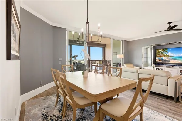 a dining room with furniture a chandelier and wooden floor