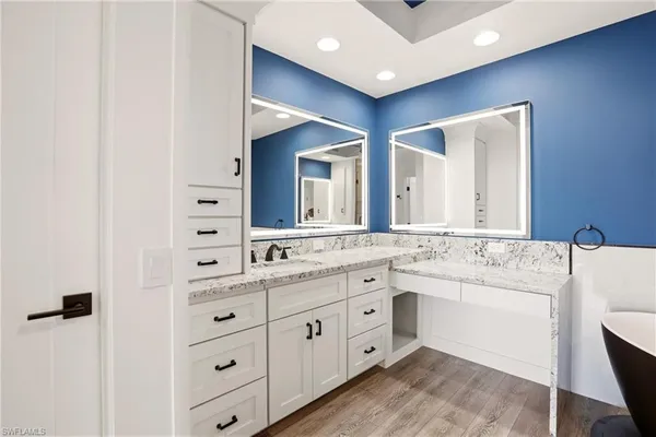a bathroom with a double vanity sink a mirror and a bathtub