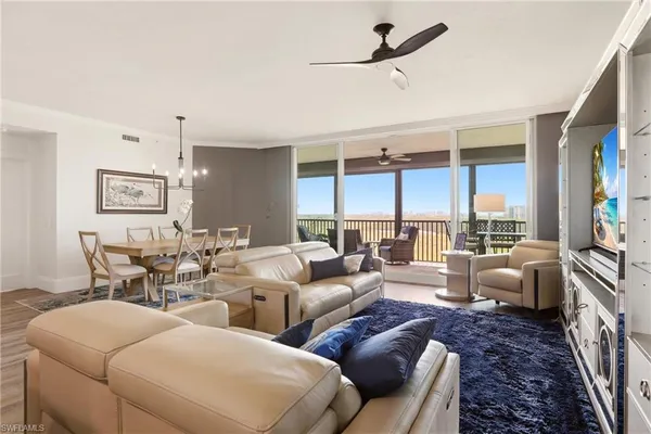 a living room with furniture ceiling fan and a large window
