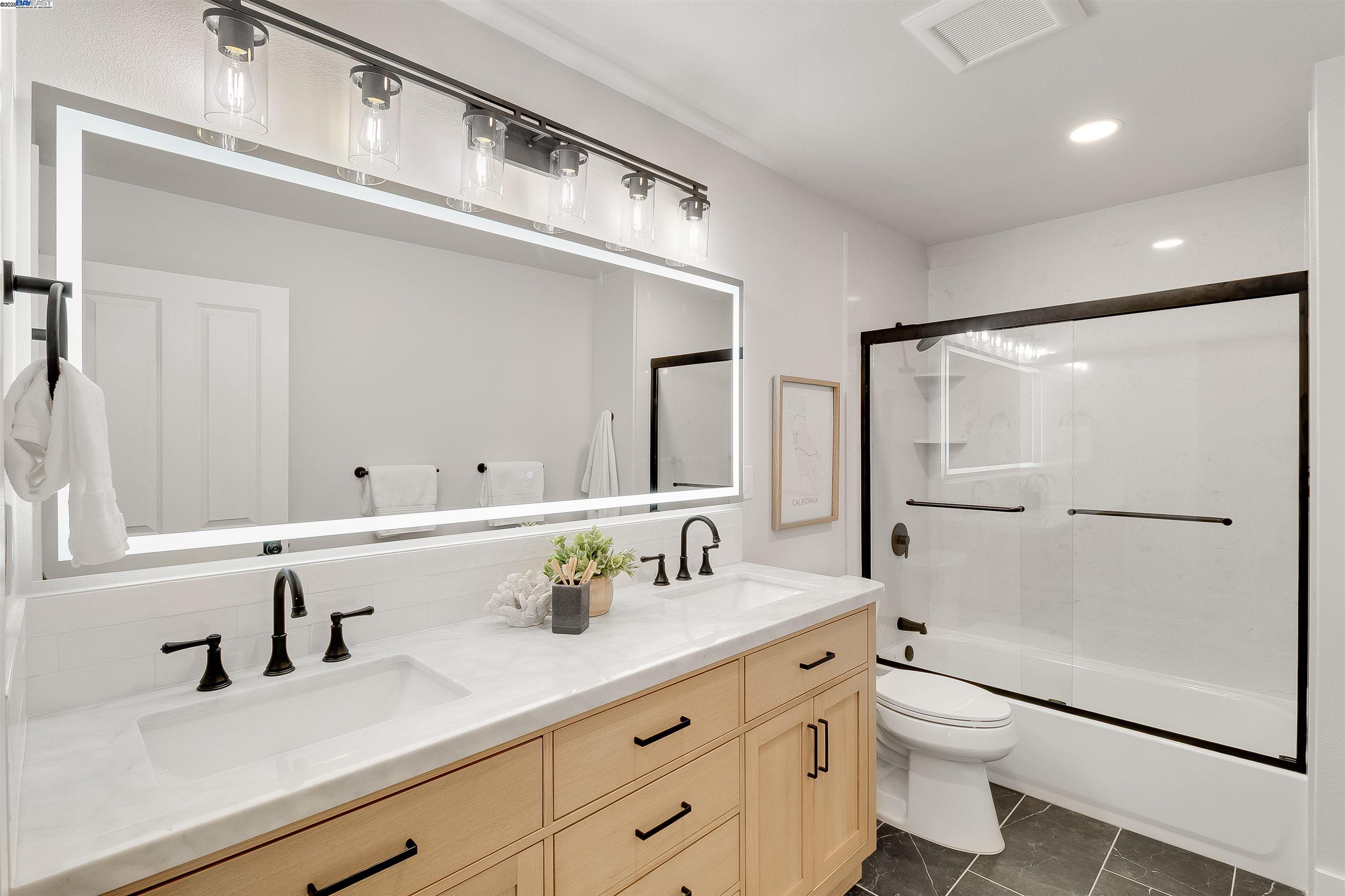 736 Adams Avenue Livermore, CA 94550 - Photo 30 of 52 a bathroom with a granite countertop sink mirror vanity and toilet
