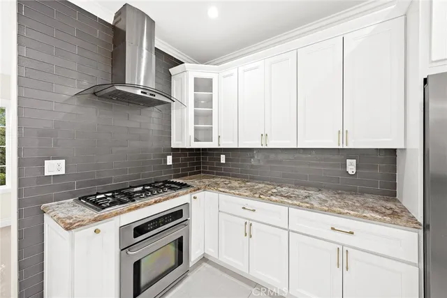 a kitchen with granite countertop white cabinets and white appliances