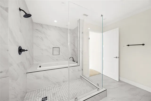 a bathroom with a glass shower door and a sink
