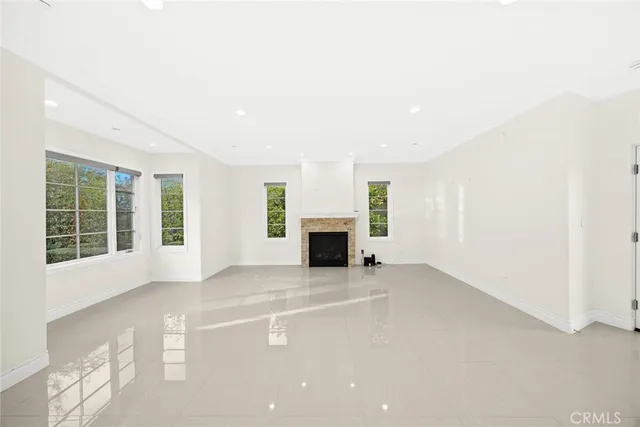 an empty room with windows and fireplace