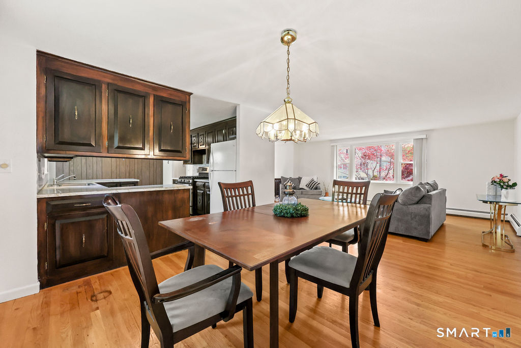 142 Wolcott Hill Road Wethersfield, CT 06109 - Photo 7 of 29 a view of a dining room with furniture a chandelier and wooden floor