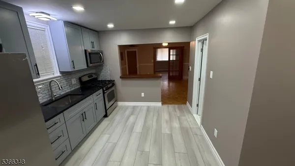 a kitchen with granite countertop a sink stove and refrigerator