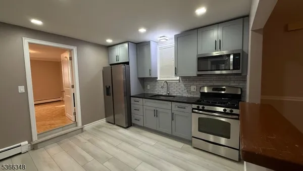 a kitchen with stainless steel appliances granite countertop a stove a refrigerator and a microwave