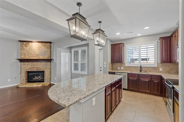 a kitchen with stainless steel appliances granite countertop a sink stove and cabinets