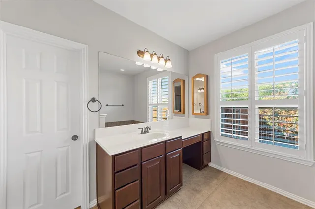a spacious bathroom with a double vanity sink a mirror and a shower