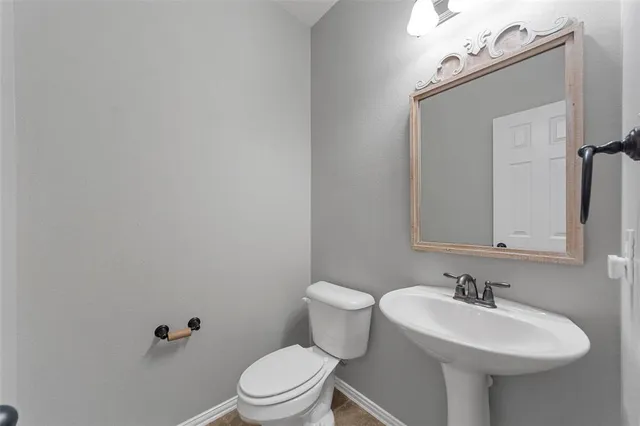 a bathroom with a sink a toilet and mirror