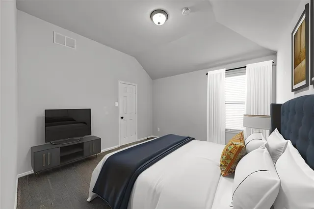 a bedroom with a bed and a television