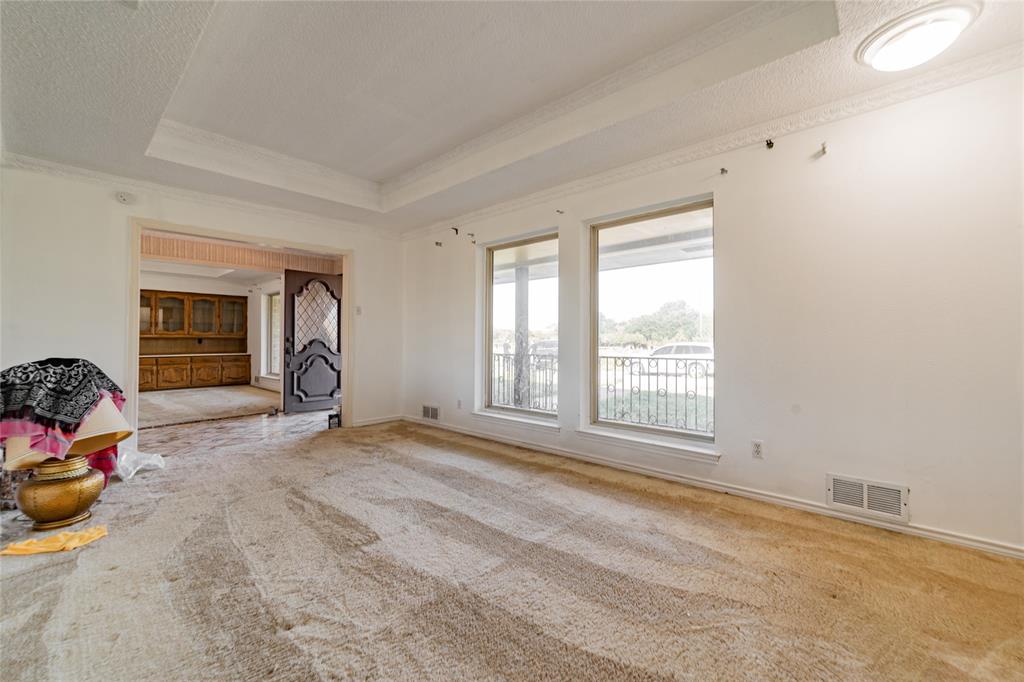 4320 Hickox Road Rowlett, TX 75089 - Photo 13 of 37 Tray ceiling with crown molding, dual large windows, and an arched doorway leading to an additional space featuring built-in cabinetry