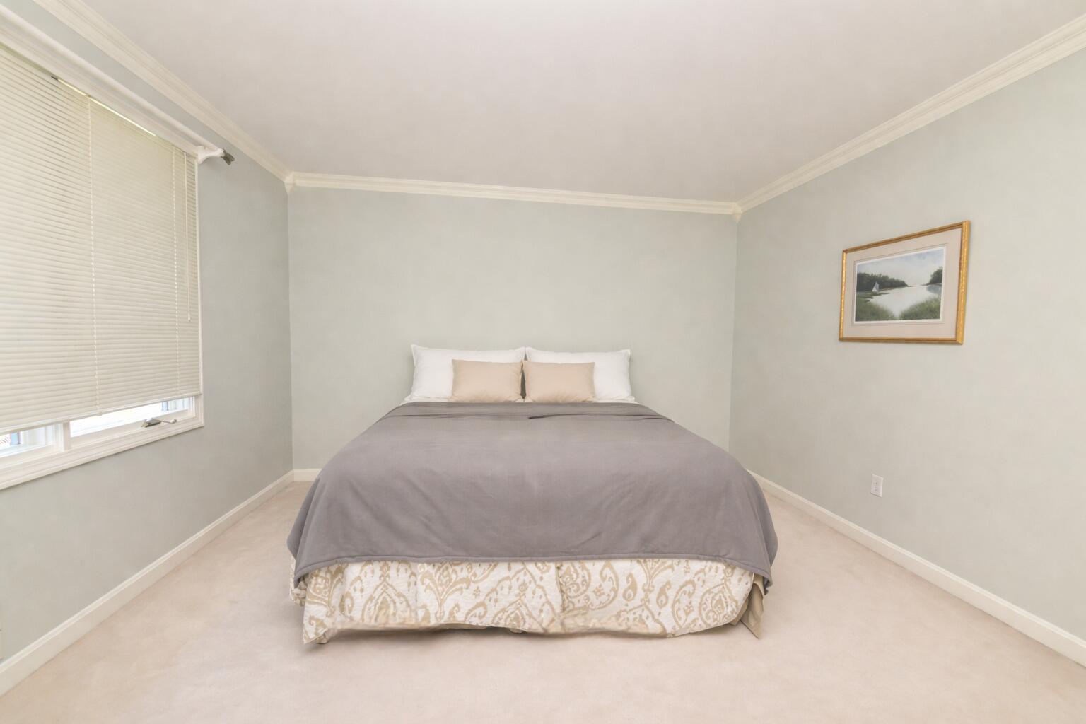 4 Bittersweet Lane, Unit 4G Buzzards Bay, MA 02532 - Photo 9 of 26 a bedroom with a bed and a painting on the wall