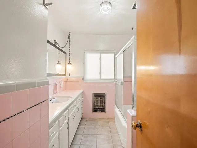 an empty room with wooden floor chandelier fan and windows