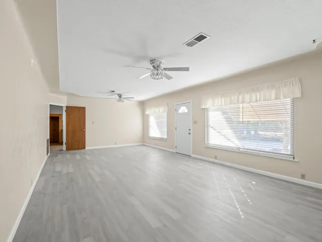 a kitchen with granite countertop a refrigerator and white cabinets