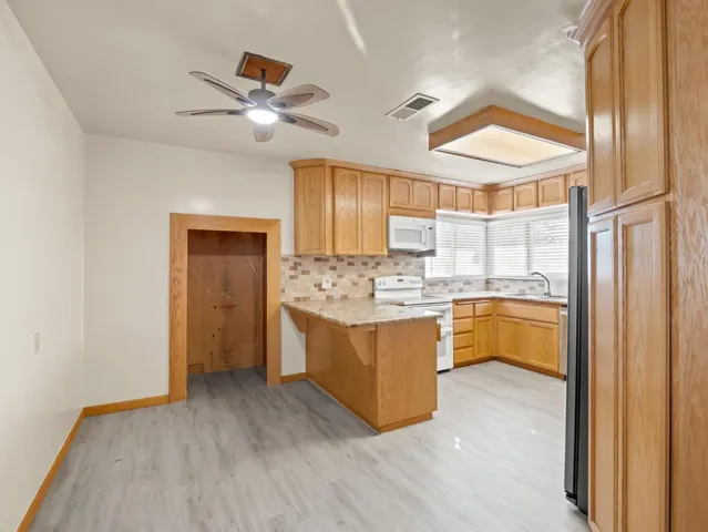 a kitchen with cabinets appliances a sink and a window