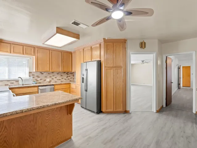 a kitchen with stainless steel appliances granite countertop a refrigerator and a sink
