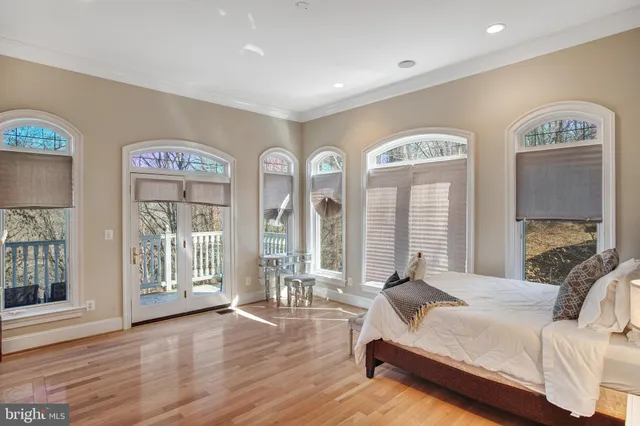 a spacious bedroom with a bed and large windows