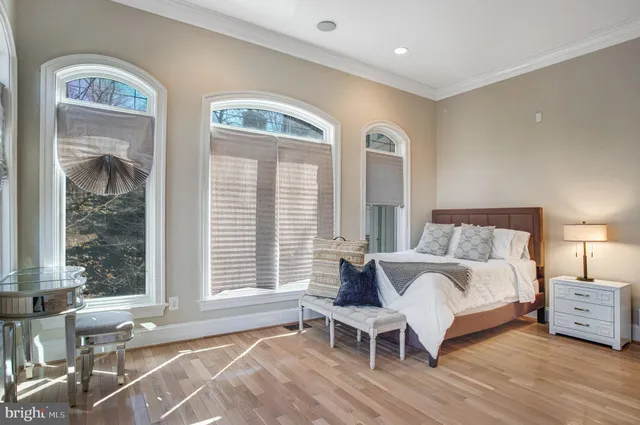 a large bedroom with furniture a flat screen tv and a fireplace