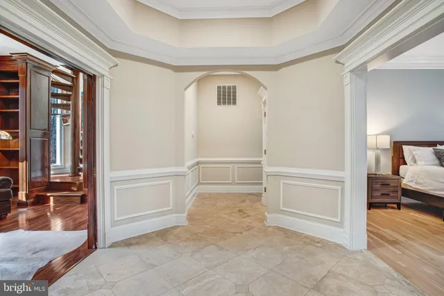 a spacious bedroom with a bed and a flat screen tv