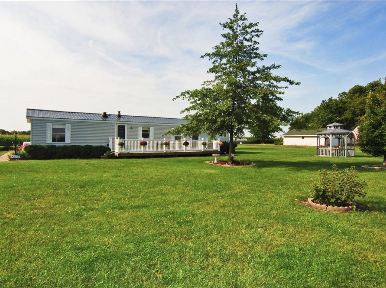 a front view of a house with a garden and trees