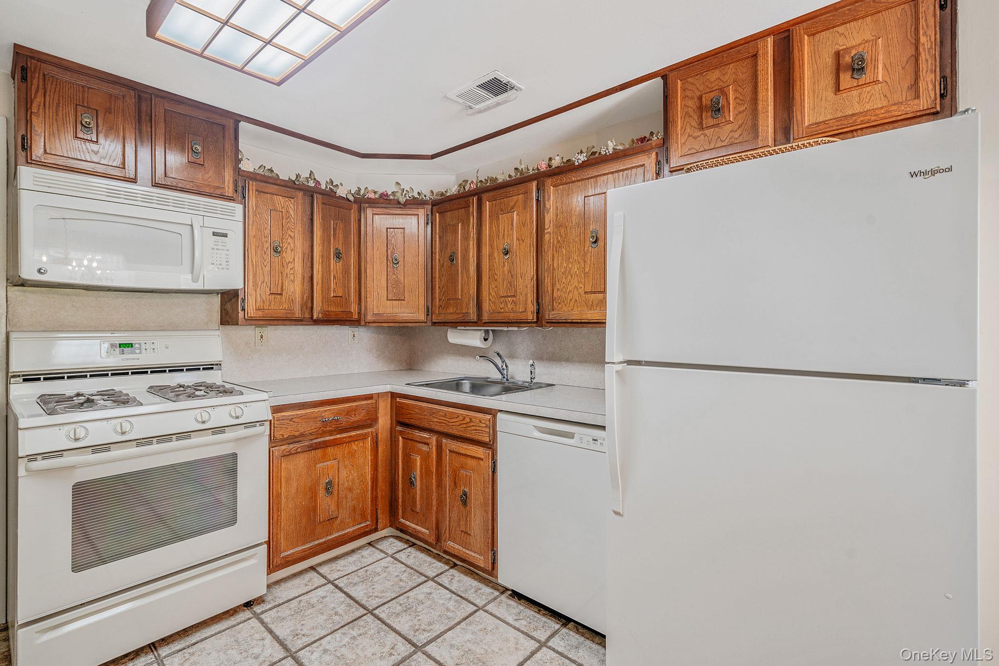 310 Birchwood Road Medford, NY 11763 - Photo 13 of 43 a kitchen with stainless steel appliances granite countertop a refrigerator sink stove and white cabinets