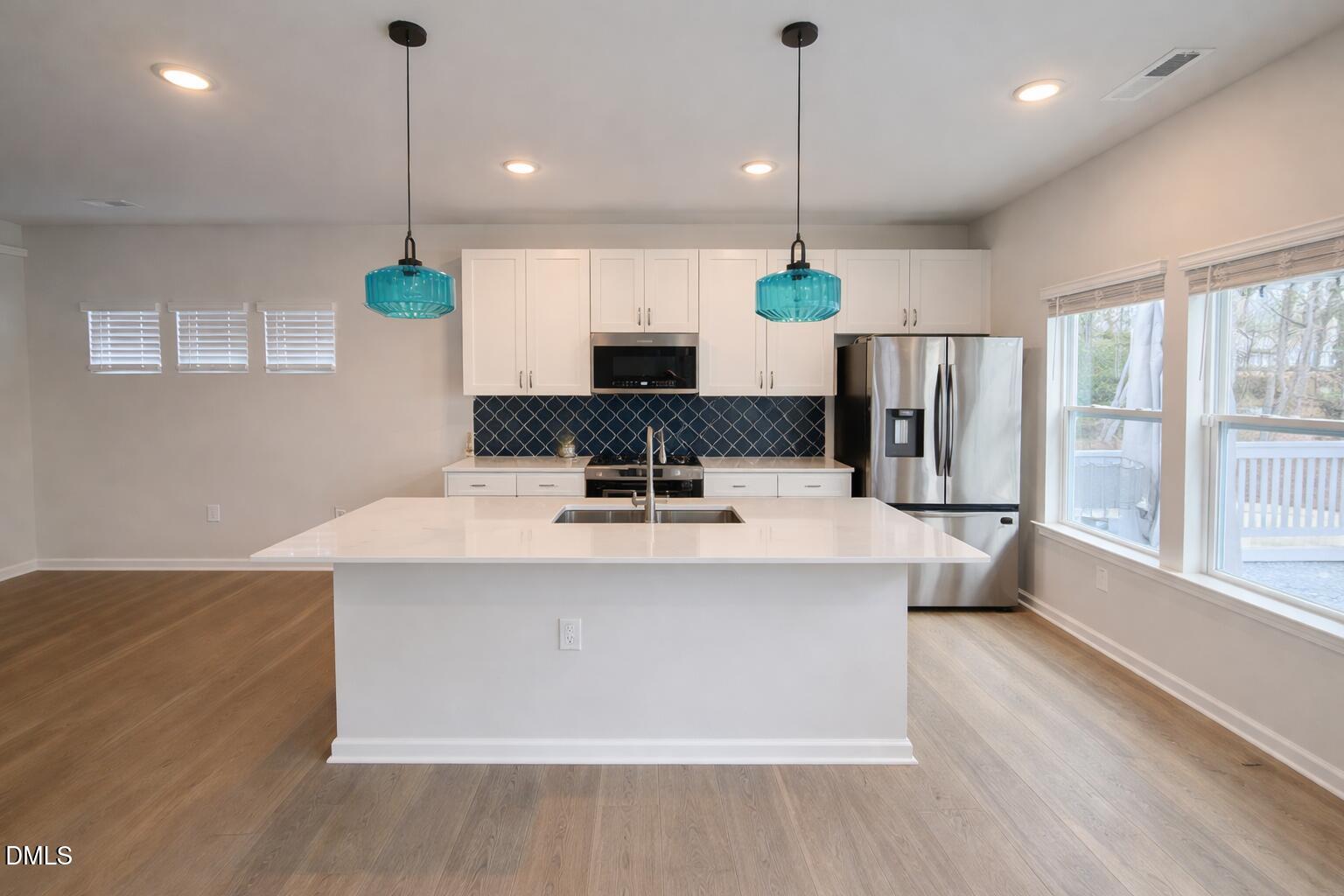 217 Beacon Hl Road Lillington, NC 27546 - Photo 9 of 24 a view of a kitchen with kitchen island a stove a sink a center island and a wooden floor