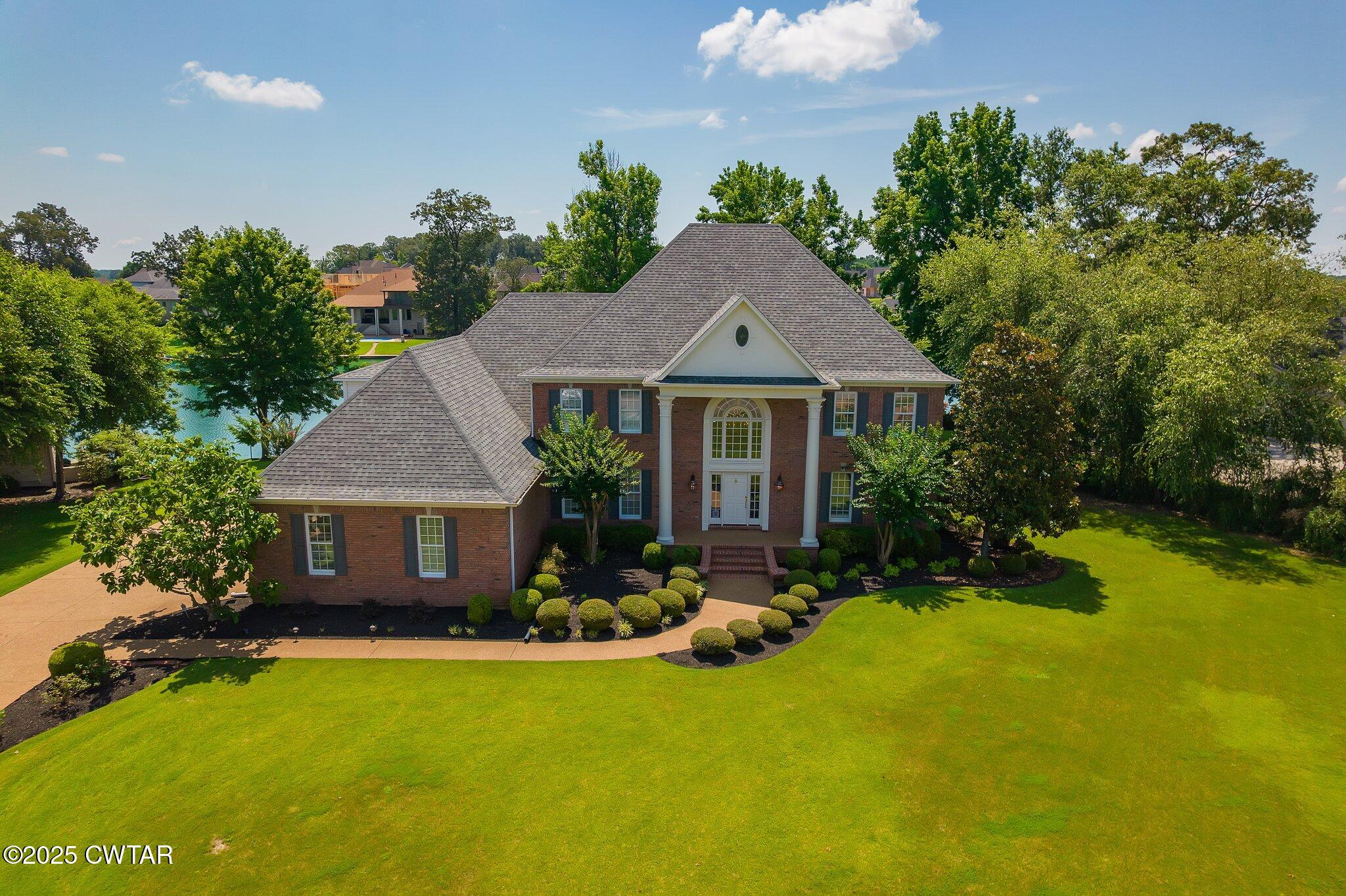 a front view of a house with yard and green space