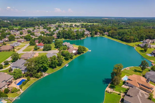 an aerial view of residential houses with outdoor space and trees