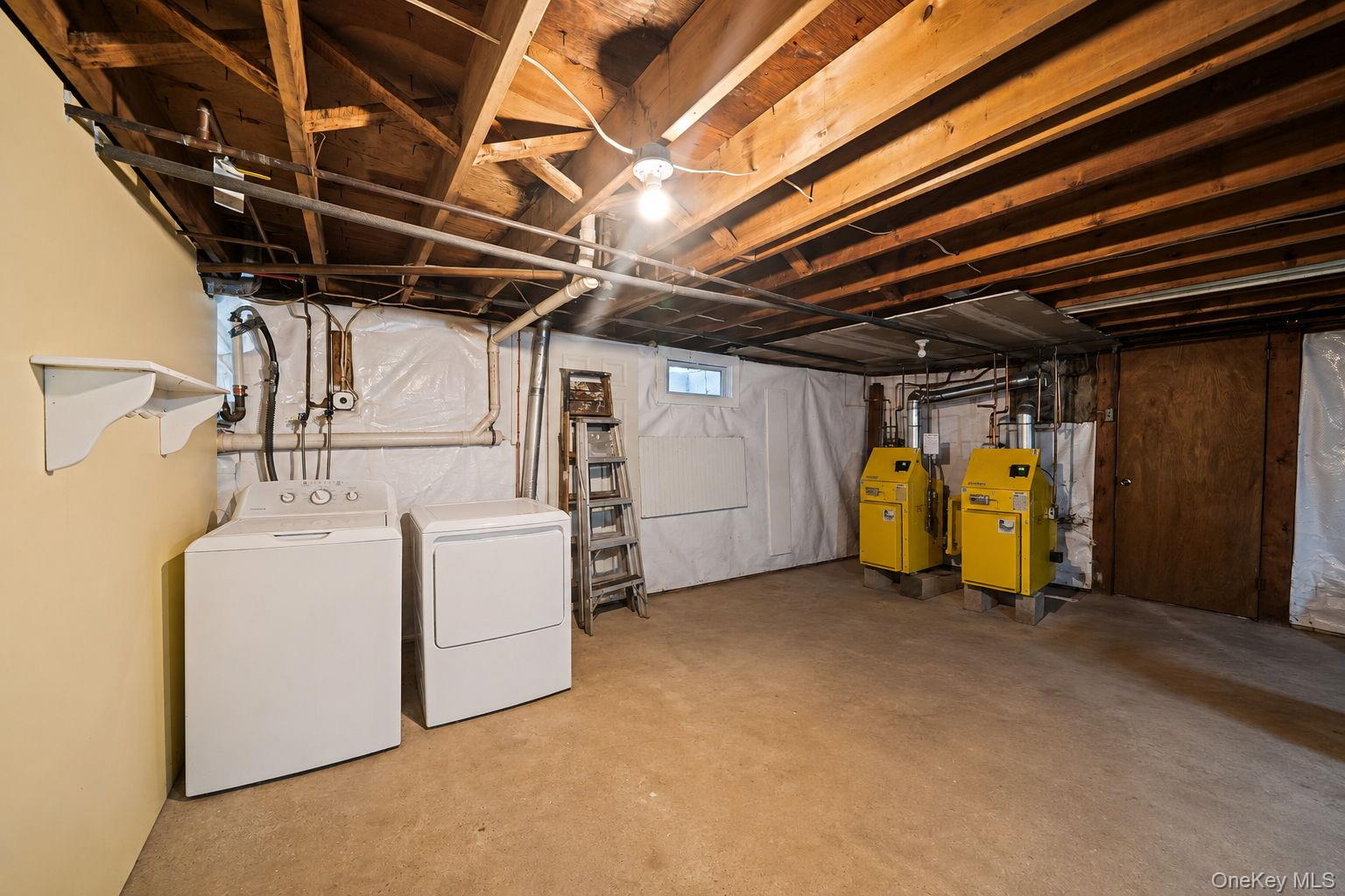 31 Crooked Hill Road Huntington, NY 11743 - Photo 25 of 32 Basement utility space featuring exposed wood joists, a washer and dryer, two yellow water heaters, and a small window