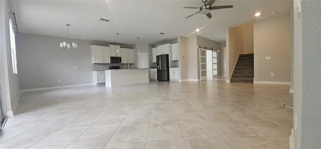 a kitchen that has a lot of cabinets and stainless steel appliances