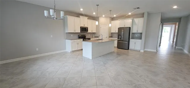 a kitchen with stainless steel appliances kitchen island a refrigerator and a sink