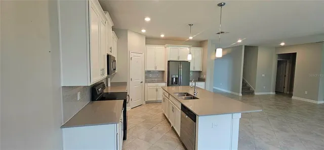 a large kitchen with a refrigerator and a sink