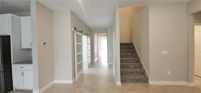 a view of a kitchen with kitchen island wooden floor center island stainless steel appliances and cabinets
