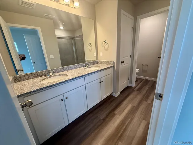 a spacious bathroom with a granite countertop sink mirror and a toilet