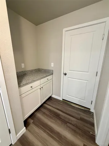 a bathroom with a granite countertop sink and white cabinets