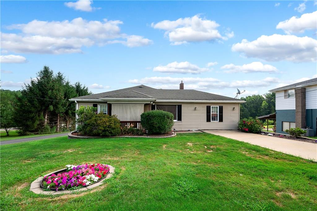 a front view of a house with a garden and trees