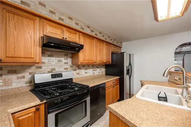a kitchen with granite countertop a sink stove and refrigerator