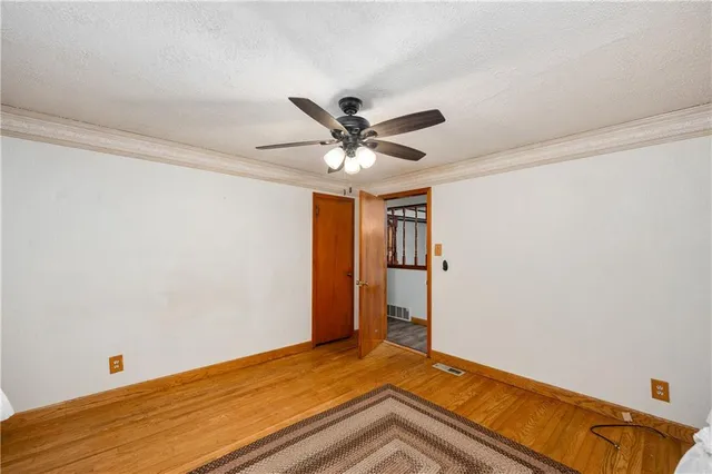 a view of a bedroom with a chandelier fan and a window