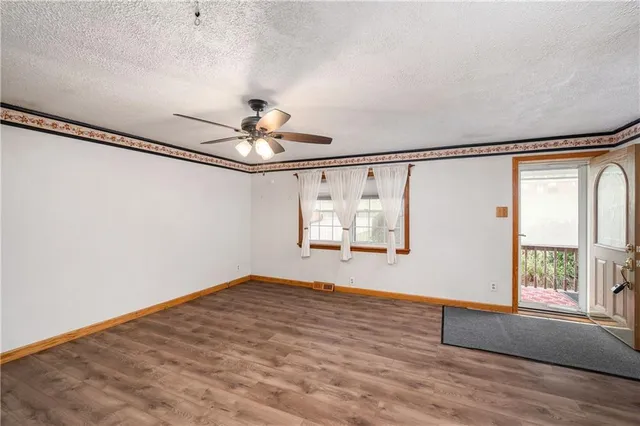 a view of a room with wooden floor chandelier and windows