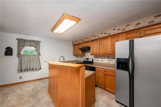 a kitchen with stainless steel appliances a refrigerator and a stove top oven