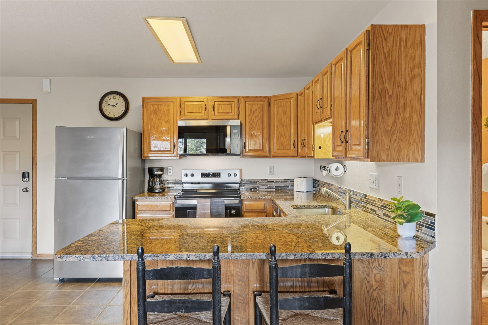 89410 Ryan Gulch Road, Unit DD301 Silverthorne, CO 80498 - Photo 11 of 28 a kitchen with kitchen island granite countertop a sink cabinets and stainless steel appliances